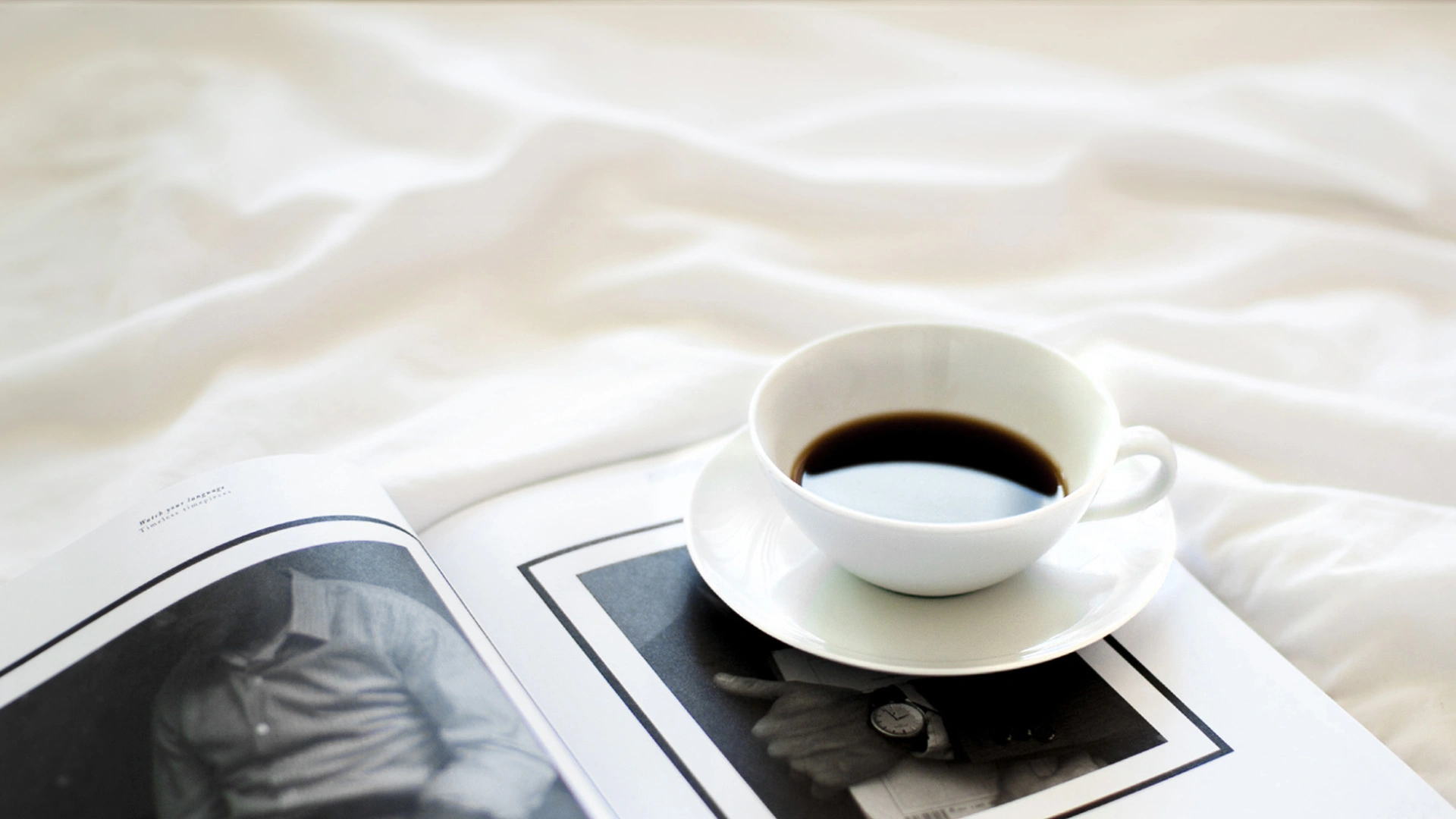 Kaffeetasse und Zeitschrift auf Decke