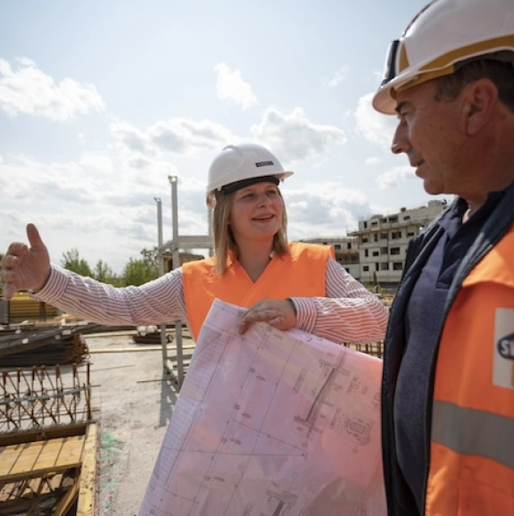 Bauarbeiterin und Bauarbeiter auf einer Baustelle von Swietelsky