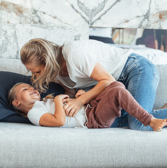 Mama und Tochter, die am Sofa kuscheln